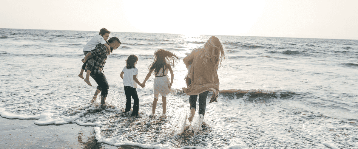 Family at the beach sticking their feet in the water