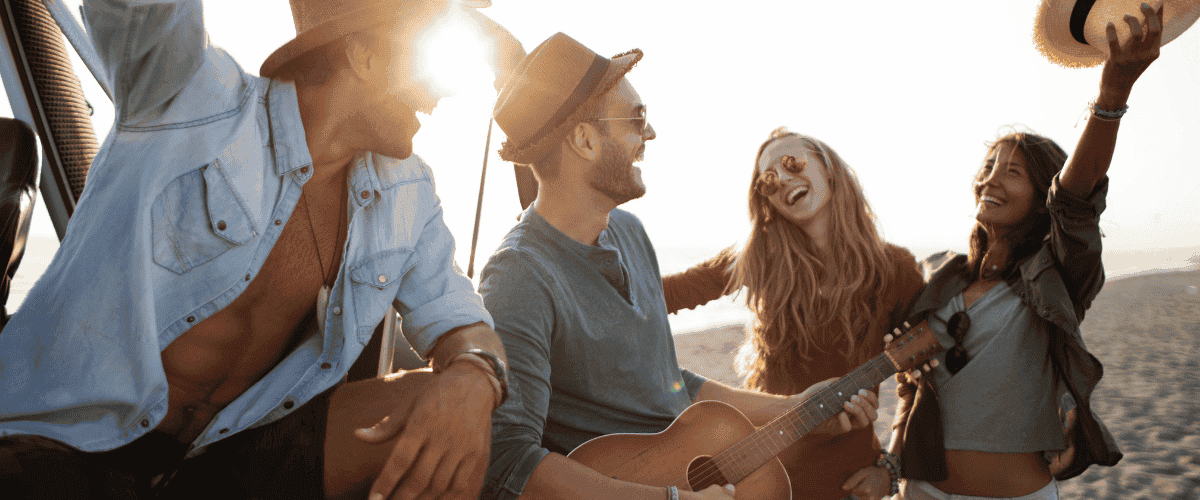 A group of friends hanging out and laughing on the beach
