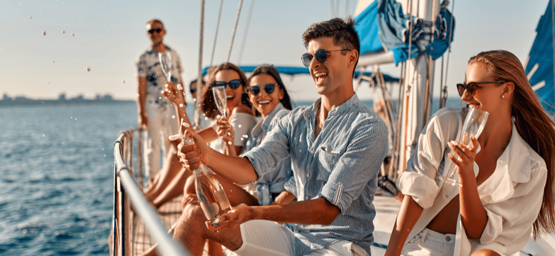 Group of friends on a boat on vacation popping a bottle of champagne