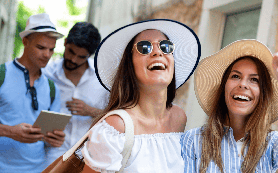 Two women with two men in the background in group travel in an alley smiling and pointing up