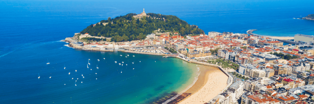 Aerial view of a city in Spain with buildings along the Mediterranean coast with water surrounding the land