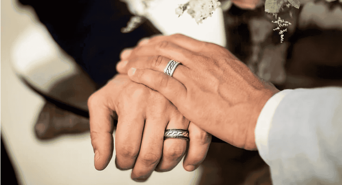 The hands of two men with wedding rings on after an LGBTQ wedding