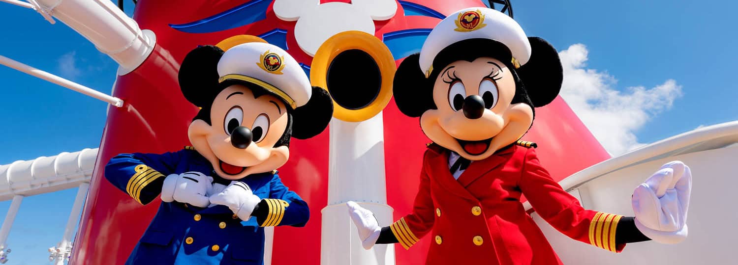 JT-Disney-12 Mickey Mouse in a blue captain’s uniform and Minnie Mouse in a red captain’s uniform stand in front of a large red smokestack with a Mickey Mouse logo.