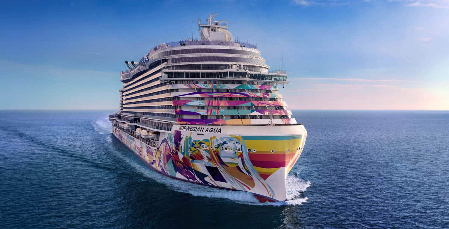 Large cruise ship named Norwegian Aqua sails on open water, featuring a colorful, abstract mural on its hull under a clear sky.