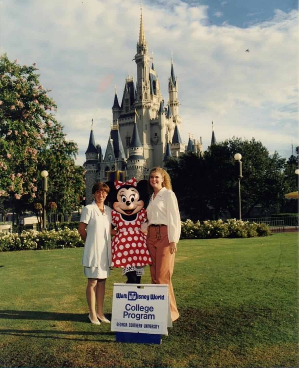 Anna-Swenson-226 Two women stand with Minnie Mouse in front of Cinderella Castle at Walt Disney World, next to a sign for the College Program and Georgia Southern University.